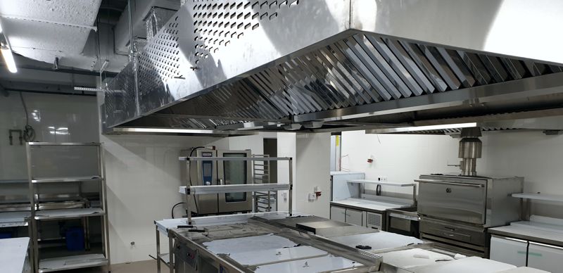Активна витяжна парасолька на кухні ресторану в процесі монтажу